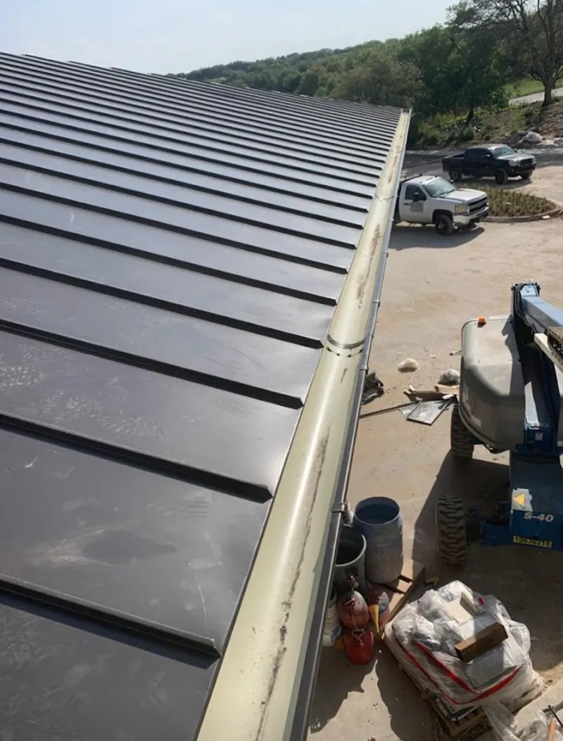 Standing seam panel and gutter detail on a metal roofing jobsite in Blythe